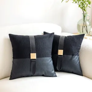 Close-up detail of luxury black decorative throw pillows with faux leather strap and buckle.