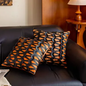 Detalle de cojin de cuero trenzado negro y naranja, cojin decorativo de lujo moderno.
