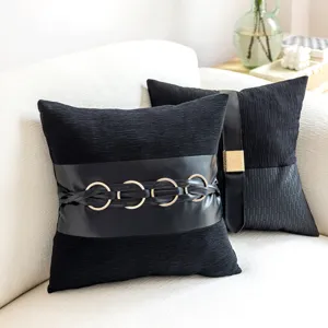 Black faux leather throw pillow cover with metallic ring accent, modern home decor detail.