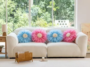 Escena de sala de estar que muestra fundas de cojín decorativas en forma de flor en un sofá.