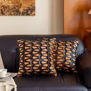 Primer plano detallado de lujosa funda de cojín de sofá decorativa naranja y negra