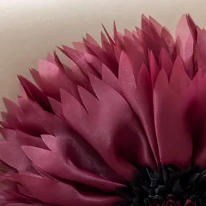 Close-up detail of 3D lotus flower pillow cover, luxury burgundy home decor cushion.