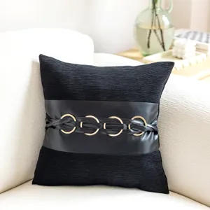 Black decorative throw pillow cover with faux leather band and gold rings for modern sofa decor.