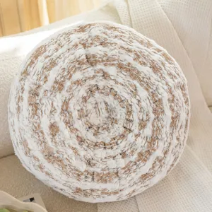Closeup of the soft round tree ring throw pillow showcasing fluffy golden and white plush texture.