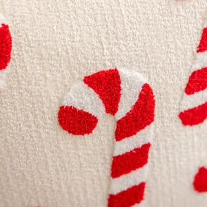 Detail shot of Christmas embroidered plush cushion cover showcasing soft texture and candy cane pattern.