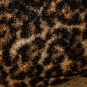 Close-up detail of soft leopard print curly fleece fabric, showing luxurious plush texture.