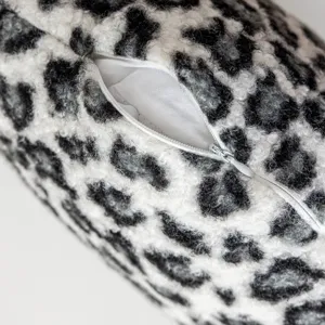 Black and white leopard print pillow cover detail showing fluffy fleece texture and zipper.