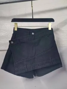 Black denim skorts detail featuring high waist design and asymmetric wrap cut for a stylish look.