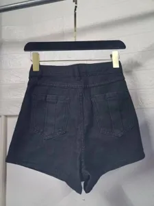 Close-up detail view of women's black high-waist denim shorts with back pocket design.