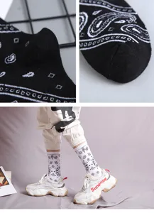 Black and white paisley pattern mid-tube cotton socks, trendy streetwear fashion design.
