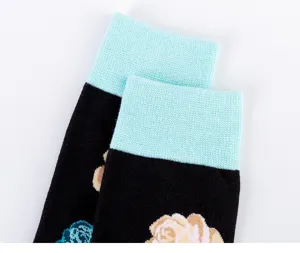 Primer plano detallado de calcetines largos negros de hombre con puños de canalé azul y flores.