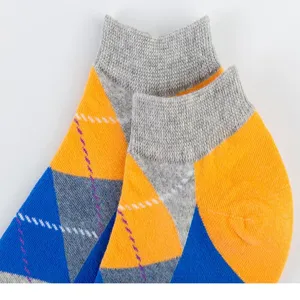 Gros plan de chaussettes courtes pour hommes avec motif géométrique coloré et bord côtelé gris.