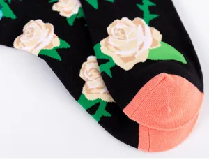 Primer plano de calcetines negros para hombre con diseño de rosas y textura de punto.