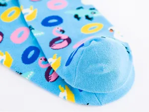 Detailopname van lichtblauwe katoenen sokken met leuke flamingo- en donutprint.