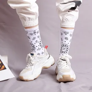 Trendy black and white paisley mid-tube cotton socks worn with white chunky sneakers.