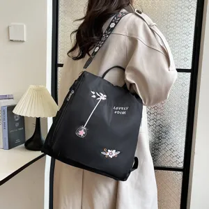 Detailed view of a black casual women's backpack with embroidery, large capacity and stylish design.
