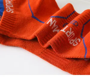 Orange sports ankle socks detail view, showing breathable knit mesh and blue stripes.