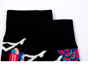 Detail view of black patterned socks showcasing the colorful woven floral cuff design and texture.