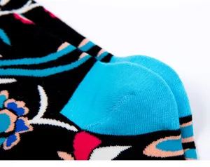 Close-up detail of stylish patterned socks with vibrant floral prints and blue heel contrast.