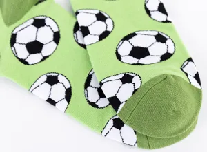 Detailed view of green men's casual sports socks featuring classic soccer ball print.
