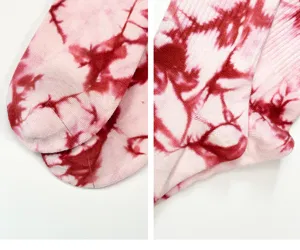 Primo piano dettagliato del motivo tie-dye rosa unico e della consistenza morbida dei calzini.