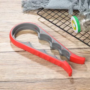 Vista dettagliata apribottiglie multifunzionale, utensile in plastica rosso e grigio quattro in uno.