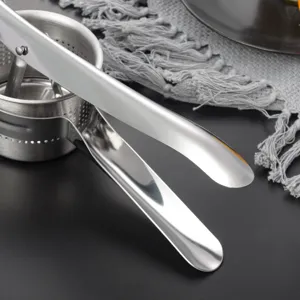 Stainless steel potato ricer detail view showing metal press bowl and handles for kitchen.