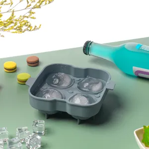 Dettaglio dello stampo per ghiaccio in silicone con quattro sfere sul tavolo verde.