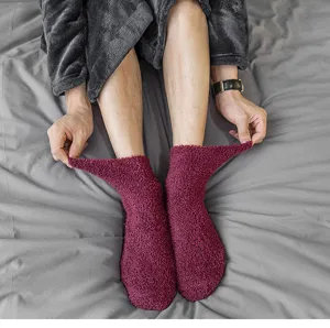 Nahaufnahme von kuscheligen dunkelroten Korallenfleece Socken, weich und warm für den Winter.