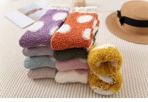 Close-up of thick coral fleece winter sleep socks with cute polka dot patterns in soft colors.