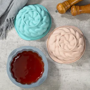 Vista dettagliata dello stampo da forno in silicone con design a spirale e utensili da cucina colorati.