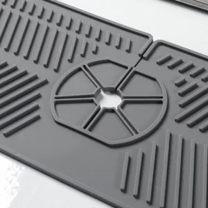 Graue Silikon-Armaturenmatte Detailansicht mit Ablaufrippen und zentralem Spülenloch.