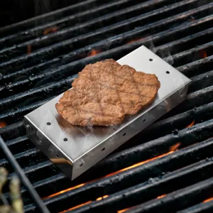 Stainless steel smoker box detail on outdoor grill, ideal for BBQ smoking enthusiasts.