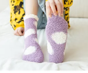 Cozy winter coral fleece plush sleep socks detail featuring cute purple polka dot pattern design.