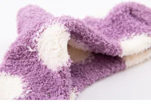 Close-up view of fluffy coral fleece women winter polka dot sleep socks showing soft plush texture.