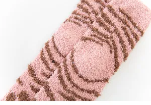Nahaufnahme kuscheliger dicker Korallenfleece Wintersocken mit rosa braunem Muster.