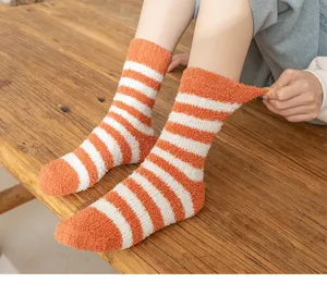 Cozy coral fleece striped mid-calf socks in orange and white, showcasing soft fuzzy winter texture.