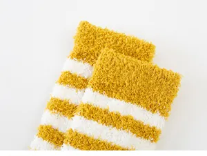 Close-up detail view of cozy coral fleece striped women socks in yellow and white, soft texture.