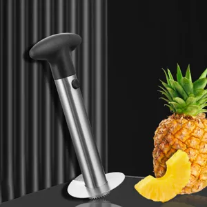 Vue détail d'un outil vide-ananas en acier inoxydable avec tranche de fruit fraîche.
