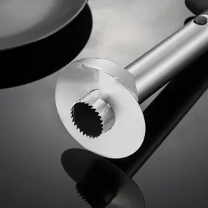 Détail d'un évidoir à ananas en acier inoxydable, lame dentelée pour couper les fruits.