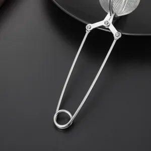 Stainless steel tea infuser strainer detail showing wire handle and mesh ball for tea.