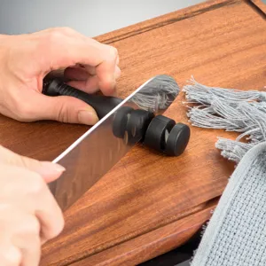 Detailed view of the manual knife sharpener in action, showing efficient sharpening wheels.