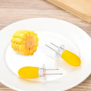 Detail close-up of stainless steel corn holders with yellow handles, perfect for BBQ and dining.