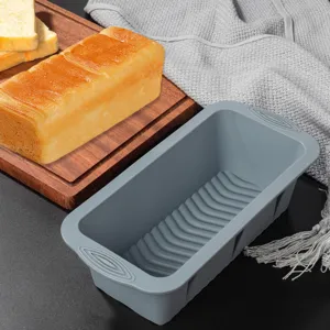 Vue de détail du moule à pain en silicone gris avec texture flexible et poignées robustes.
