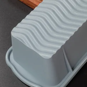 Gros plan de détail d'un moule à pain en silicone gris, texture ondulée pour pâtisserie.
