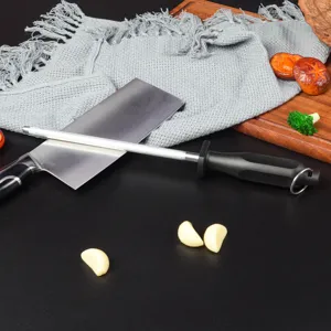 Detail shot of kitchen sharpening steel tool with knife, garlic cloves and wooden board setup