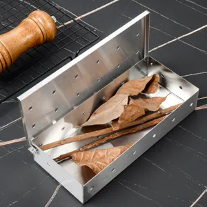 Stainless steel smoker box detail view, barbecue wood chips holder with holes for outdoor grill.