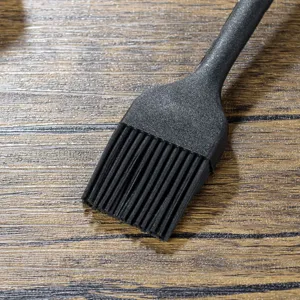 Detailed close-up view of a black silicone basting brush for kitchen baking and BBQ use.