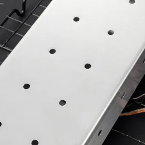 Stainless steel smoker box for outdoor BBQ grill, rectangular box with ventilation holes.