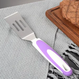 Detailansicht des Edelstahl-Käsespatels mit geschlitzter Metallklinge und ergonomischem violettem Griff.